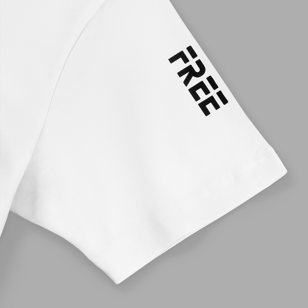 Close-up of left white t-shirt sleeve with bold black FREE text printed vertically