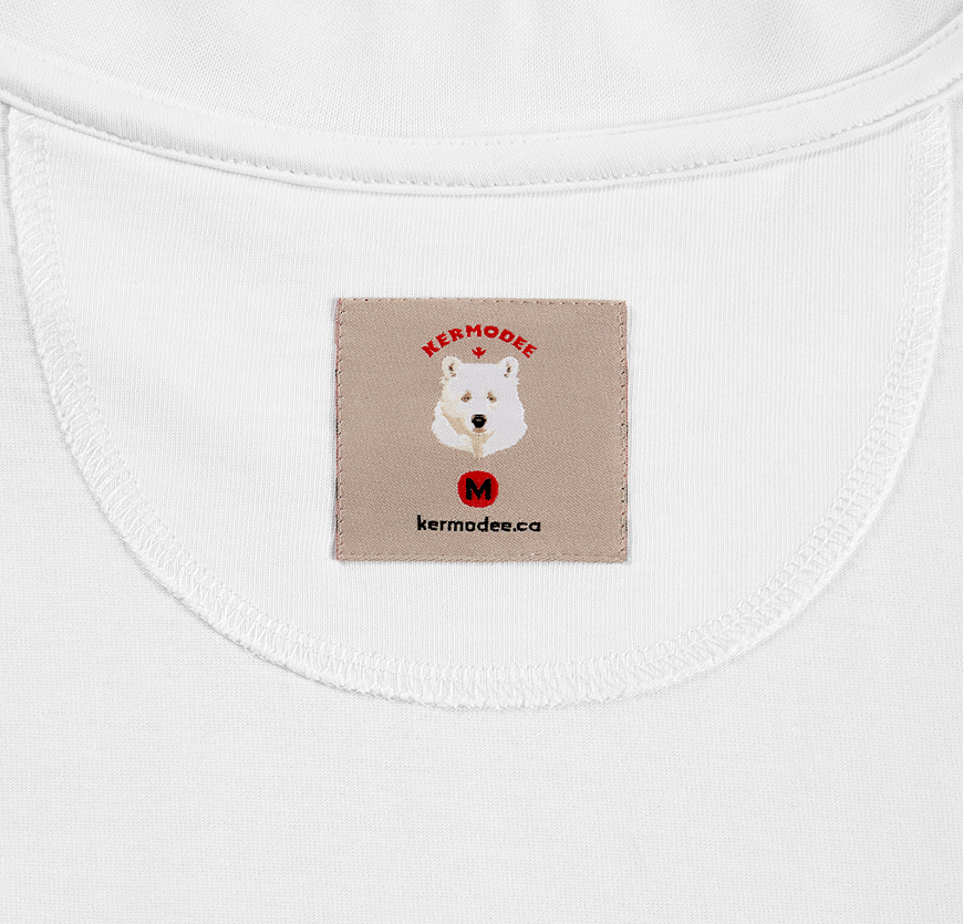 Close-up of inside woven label with Kermodee bear logo and website on white t-shirt