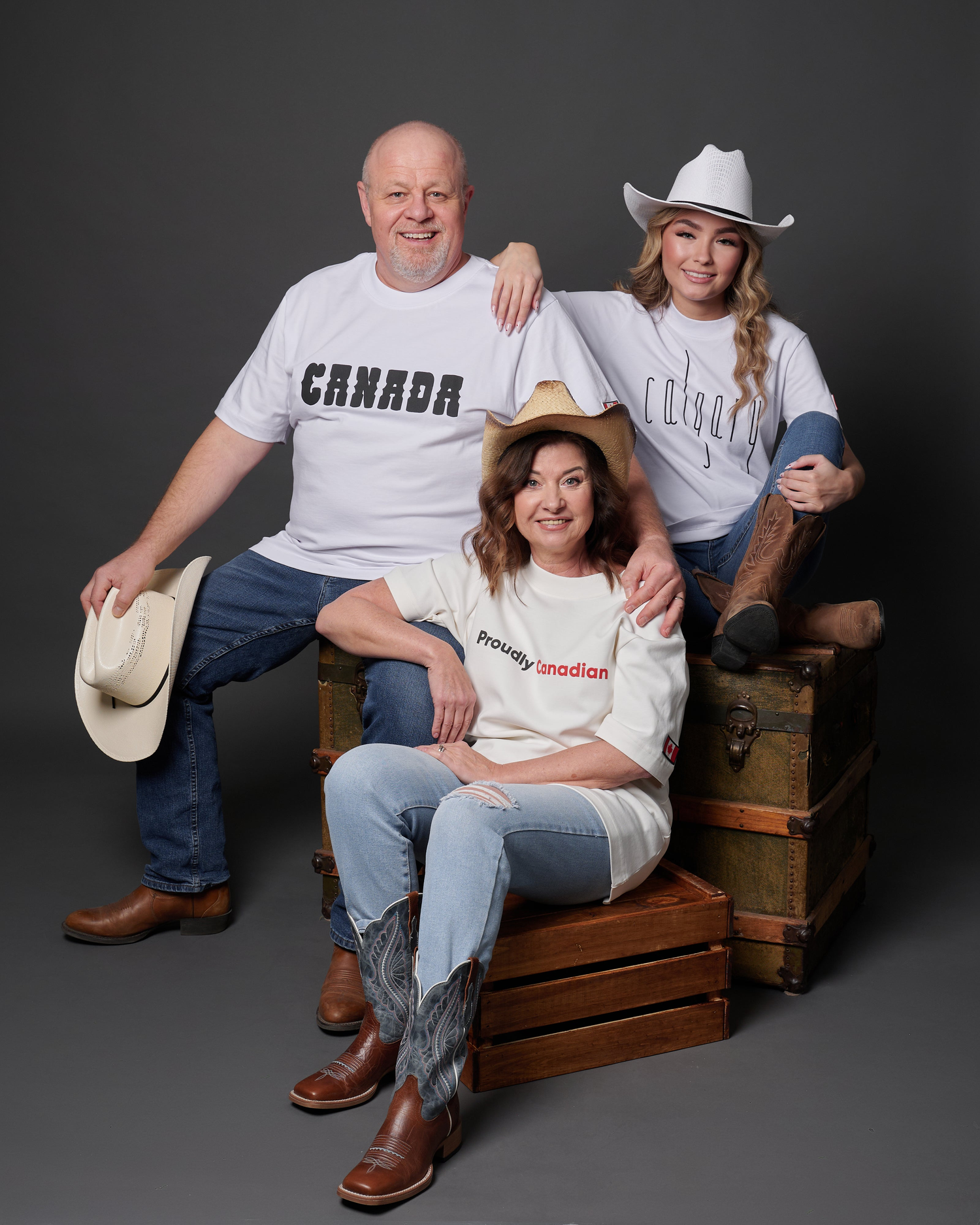 Three generations wearing Kermodee t-shirts with cowboy= hats and boots, proudly celebrating Canadian identity.