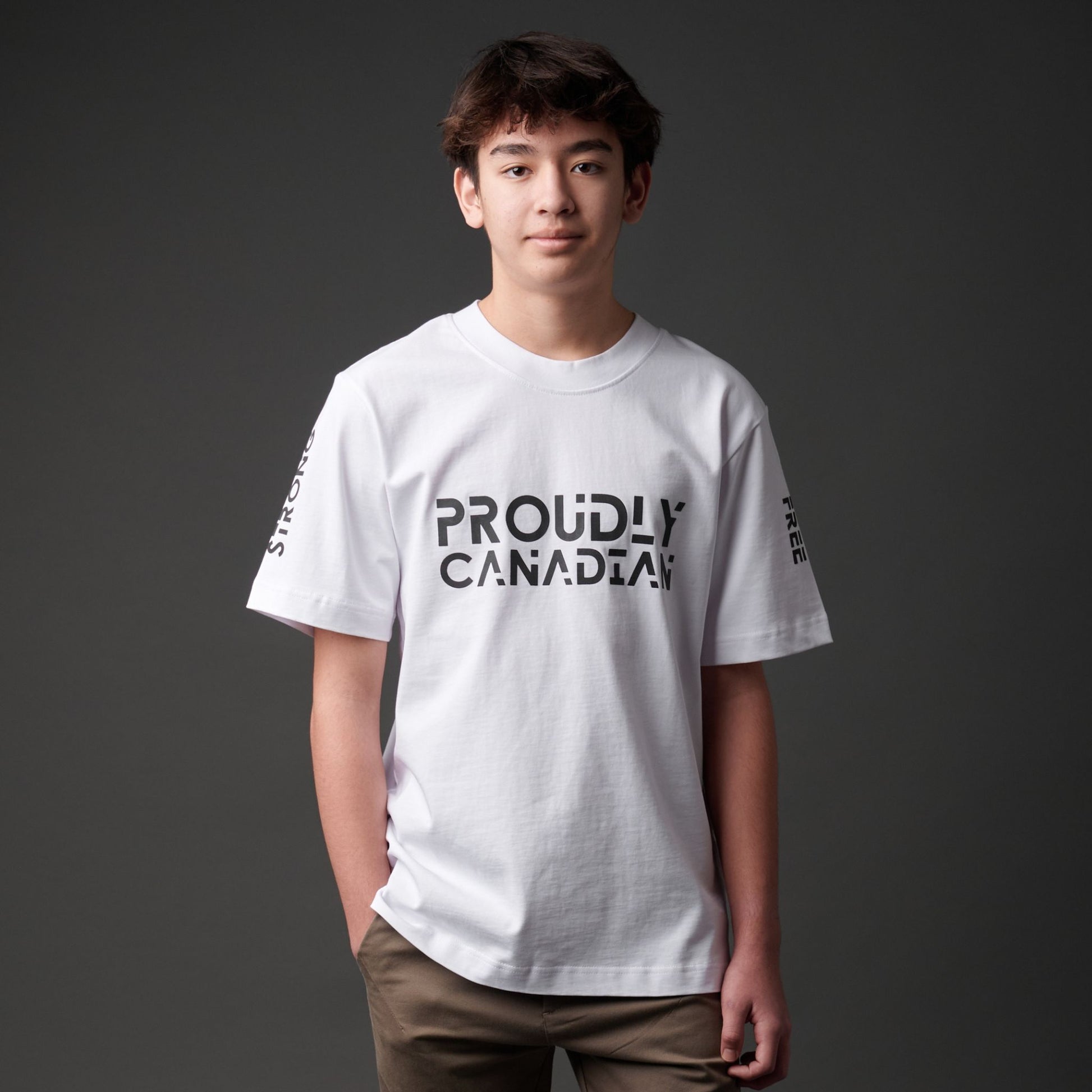 Male model wearing Strong and Free Proudly Canadian Unisex T-Shirt featuring raised high-density Proudly Canadian typography