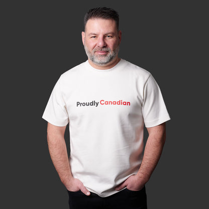Male model wearing Proudly Canadian Unisex T-Shirt featuring raised high-density red Canadian and black Proudly typography on off-white cotton blend fabric