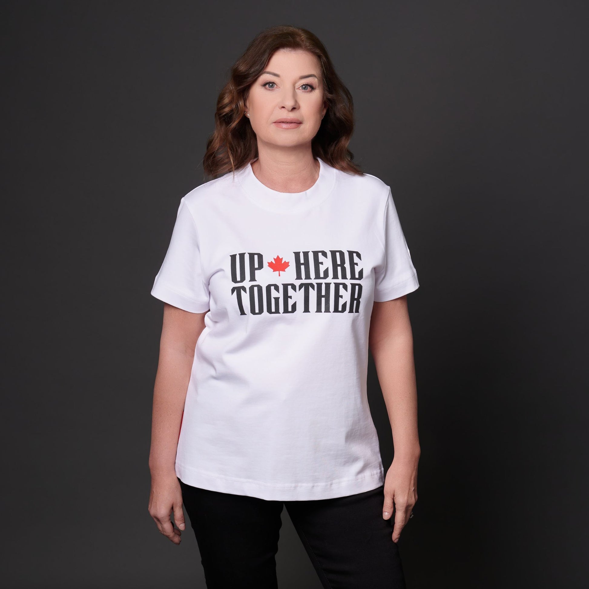 Female model wearing Up Here Together Women's Canada Unity T-Shirt with raised black lettering and red maple leaf graphic