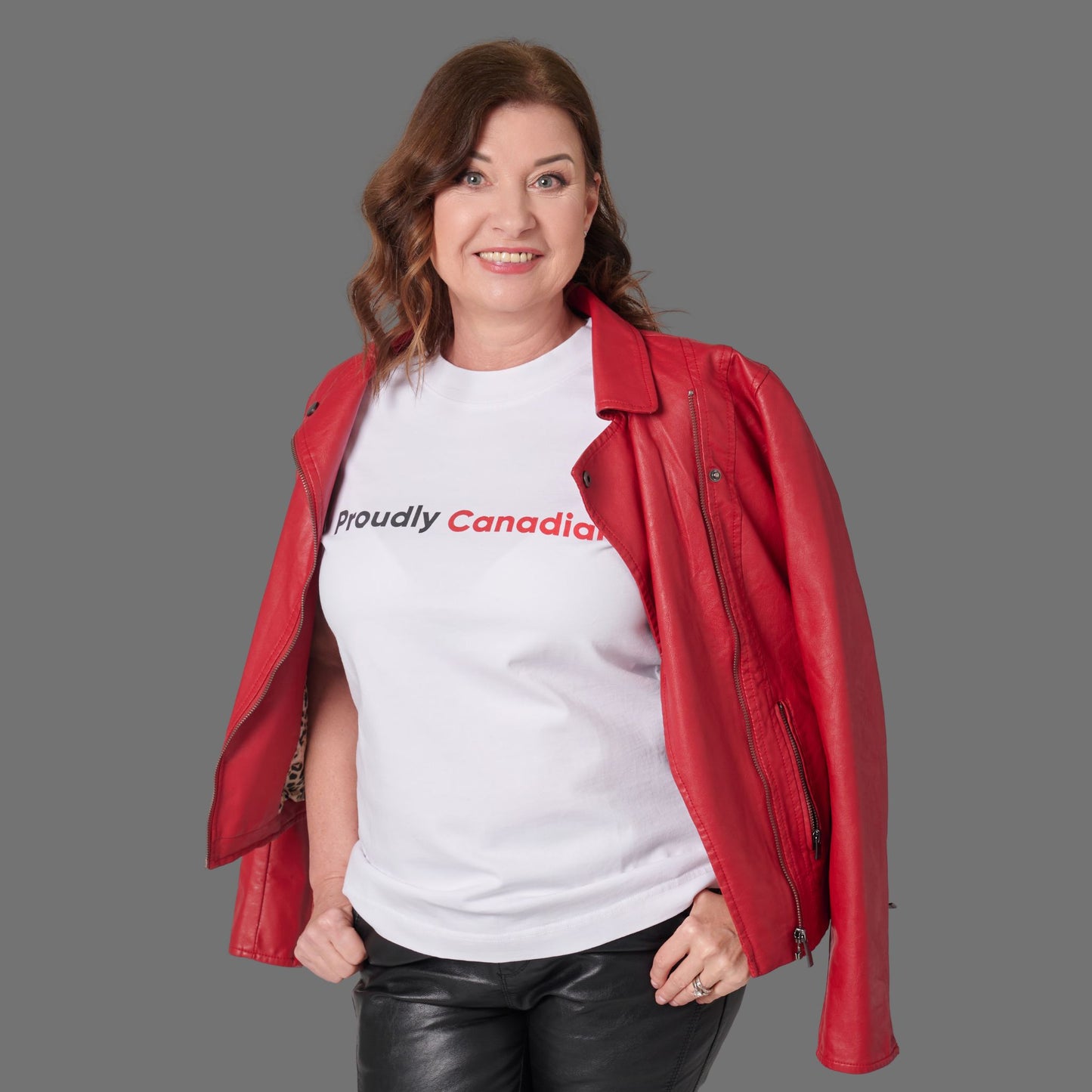 Female model wearing Proudly Canadian Women's T-Shirt in premium white cotton with raised high-density typography and red jacket styling
