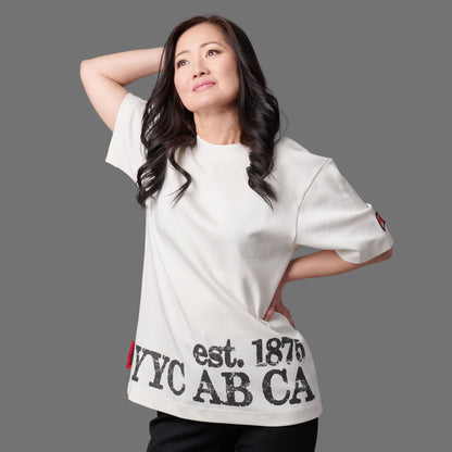 Female model wearing Calgary Alberta Heritage Unisex T-Shirt showing relaxed unisex fit and distressed YYC AB CA EST. 1875 print