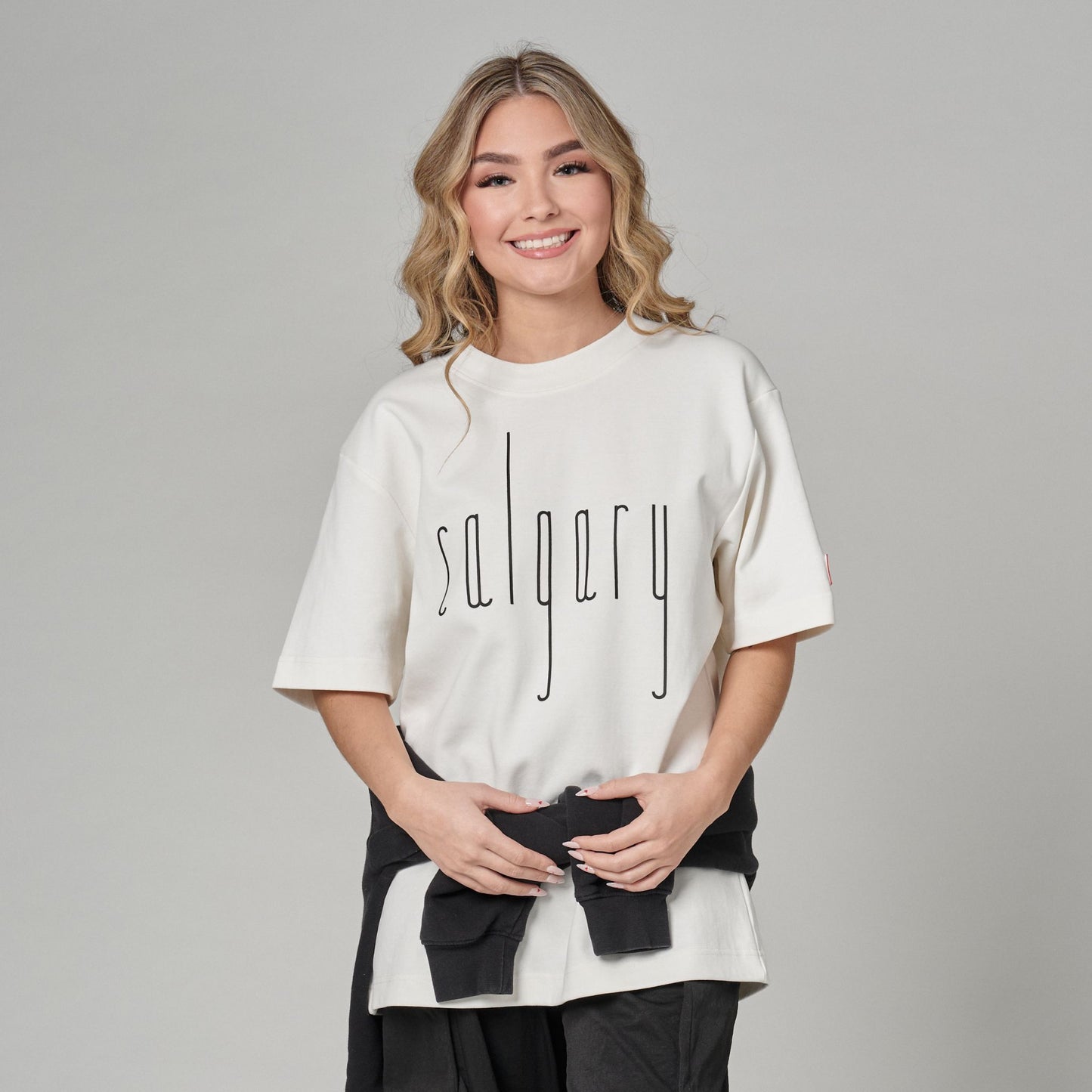 Female model wearing Calgary Alberta Unisex T-Shirt with Canadian City Pride design and raised Calgary lettering