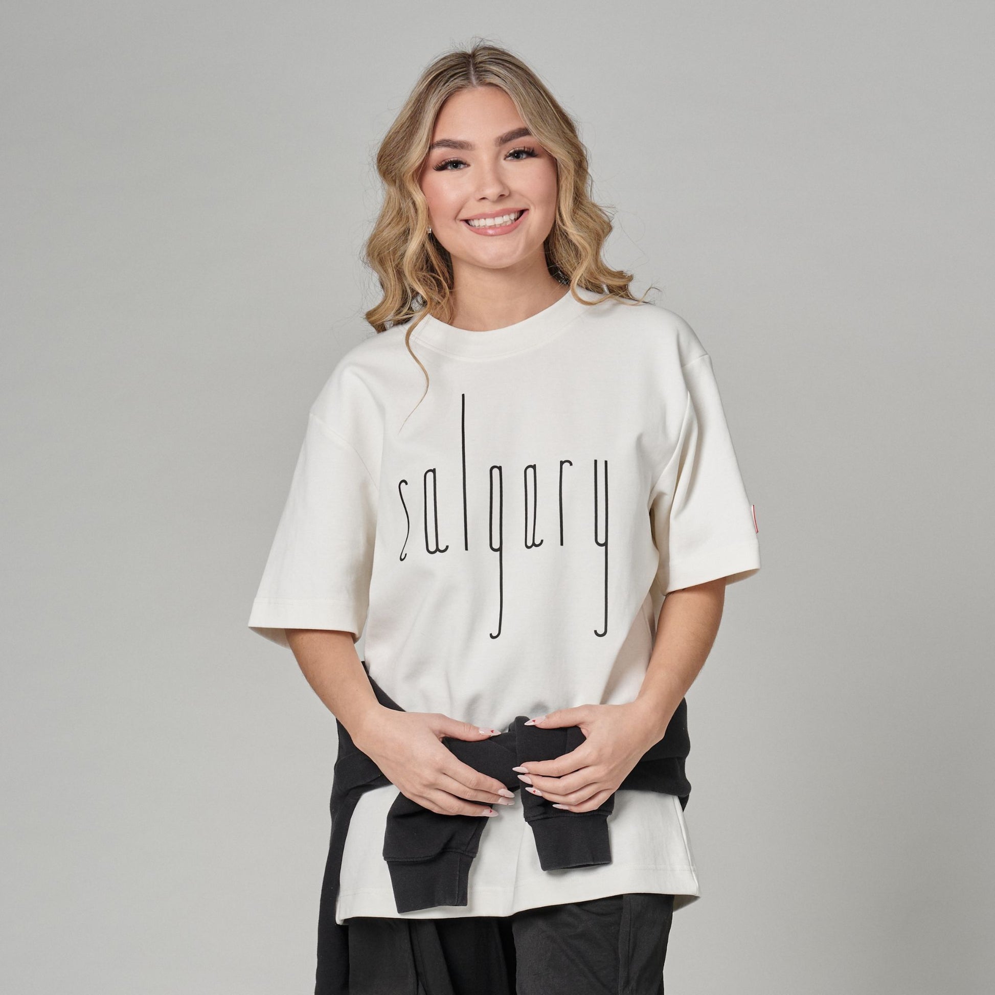 Female model wearing Calgary Alberta Unisex T-Shirt with Canadian City Pride design and raised Calgary lettering