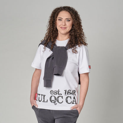 Female model wearing Montreal Quebec Heritage Unisex T-Shirt featuring distressed YUL QC CA EST. 1642 heritage print