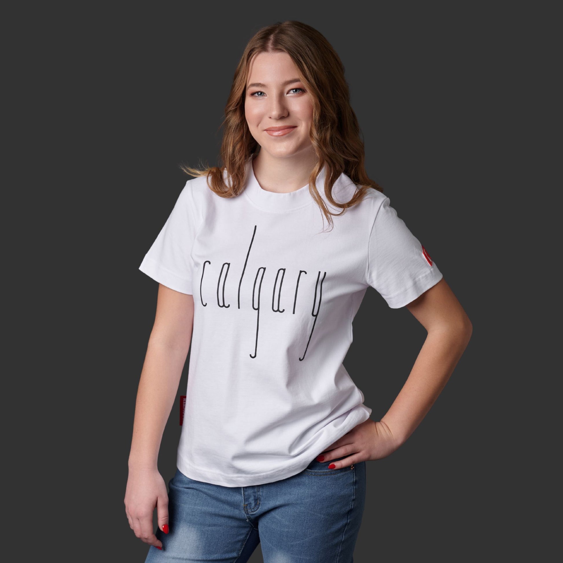 Female model wearing Calgary Alberta Women's T-Shirt featuring raised high-density Calgary typography and Canadian City Pride design