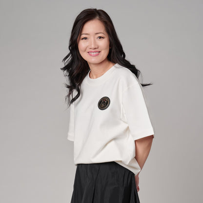 Female model wearing Kermodee Spirit Unisex T-Shirt showing front emblem and classic unisex fit