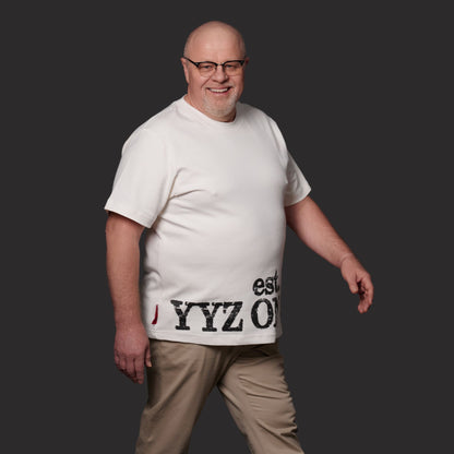 Male model wearing Toronto Ontario Heritage Unisex T-Shirt showing relaxed fit and distressed YYZ ON CA EST. 1834 print