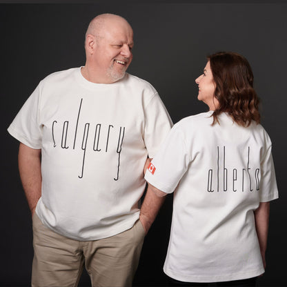 Male and female models wearing Calgary Alberta Unisex T-Shirts with Canadian City Pride design and raised Calgary lettering showing front and back views
