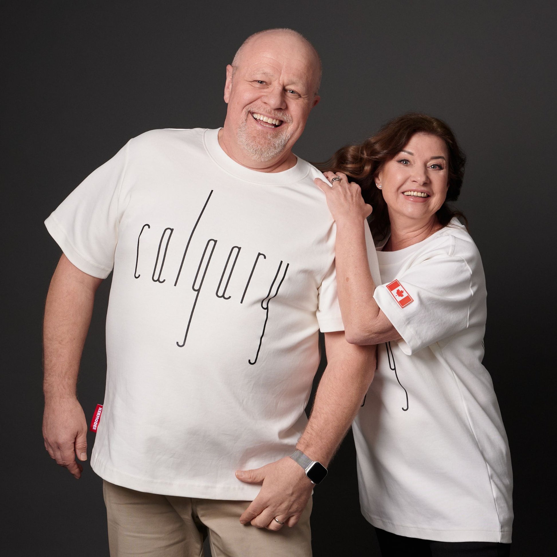 Male and female models wearing Calgary Alberta Unisex T-Shirts with Canadian City Pride design and raised Calgary lettering showing front and back views
