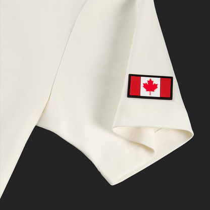 Close-up of Canadian flag patch on left sleeve of white cream Calgary Heritage t-shirt