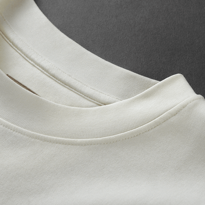 Close-up of ribbed crew neckline with visible stitch on white cream Kermodee t-shirt