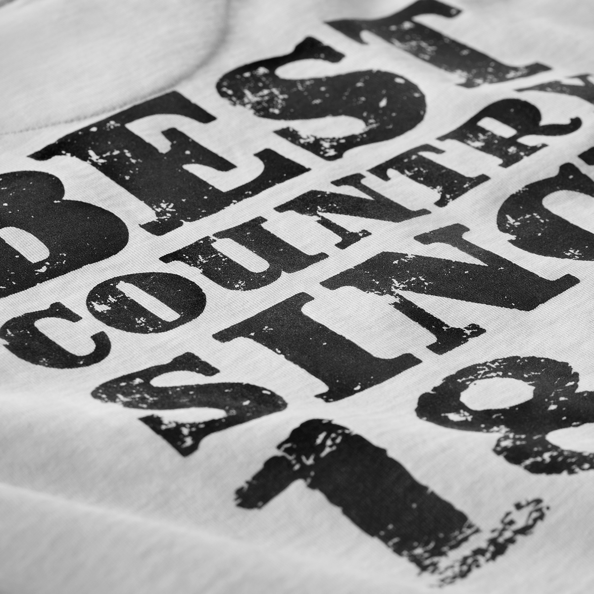 Close-up of distressed black Best Country Since 1867 print on white Kermodee t-shirt