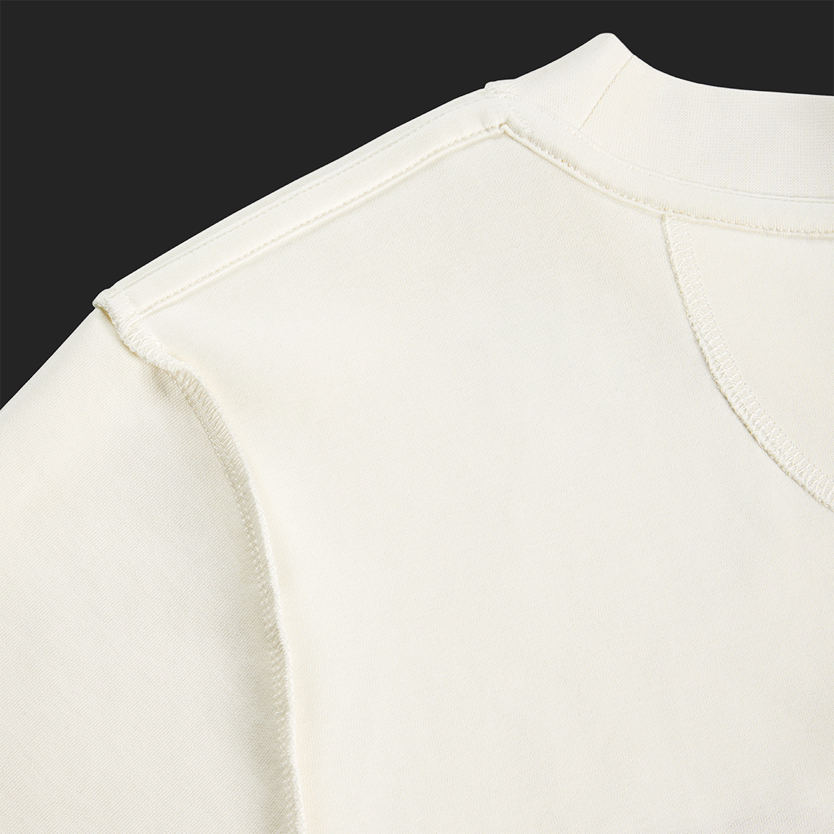 Close-up of inside seam and shoulder stitching on white cream Kermodee t-shirt