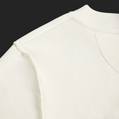 Close-up of inside seam and shoulder stitching on white cream Kermodee t-shirt