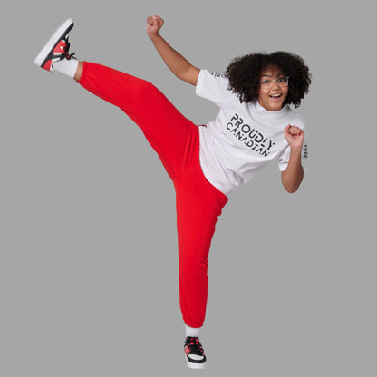 Athlete performing high kick while wearing Strong and Free Proudly Canadian Unisex T-Shirt featuring raised high-density Proudly Canadian typography